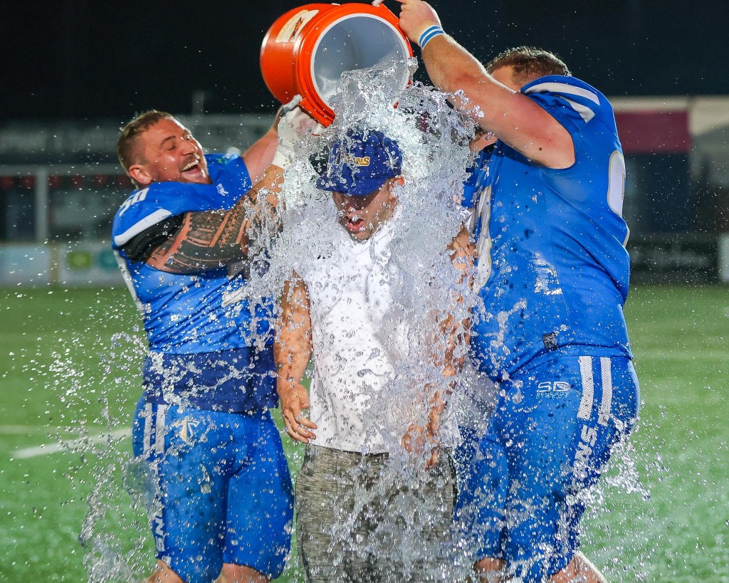 Manchester Titans celebrating with dumping a bucket of water.